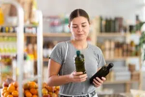 woman choosing an olive oil at the store
